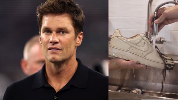 Tom Brady holding a white Nike sneaker over a sink.